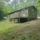 Standalone raised cabin in a wooded setting — good distinct close-up of cabin type and site surroundings, matching cabin images on the campground site.