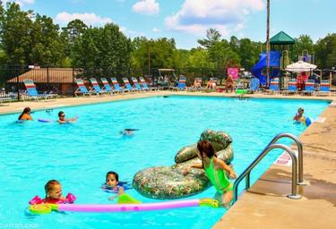 Outdoor swimming pool with loungers, children and poolside facilities — demonstrates on-site recreational amenities shown on the property page.