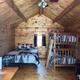 Cozy wooden cabin bedroom with bunk and double beds.