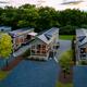Aerial 'eagle-eye' view showing multiple on-site cottages, gravel drives and surrounding tree line — clearly an overview of the Serenity Ridge cottage cluster (file from the site's Cottages/Gallery pages).