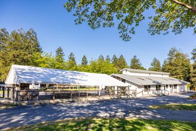 Wide exterior shot of a large covered facility/building and adjacent grounds — useful for showing campground amenities and common areas (labeled in 'ways to stay' images).