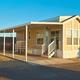 Exterior of a manufactured/mobile cottage with covered carport and small porch — represents rental/cottage accommodation available on the property. 