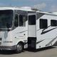 Wide shot of a large white motorhome with multiple slide-outs on the company lot; included on the site homepage and useful to show fleet variety and layout of the rental/display area (page: Motorhome Rentals and Service Center).