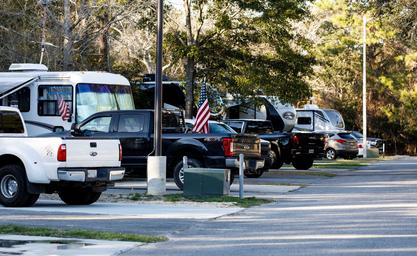 Close view of an RV row and parking pads with utility pedestals and guests' vehicles — useful detail of site setup; from the park homepage images.