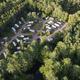 Clear aerial drone view showing the campground layout with RVs, drives, wooded surroundings and adjacent water — good overall overview of the property (file labeled as aerial view on the property page).