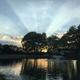Wide shot of the on‑site reflecting/stocked pond with fountain at sunset and campground trees/cabins in background — matches the site background image and highlights a key on‑site amenity.