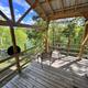 Deck of a glamping cabin/tent with chairs and railing overlooking treed shoreline — clear on-site accommodation photo suitable for property gallery. Source: contact page (lakecumberlandglamping.com/contact).
