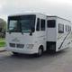 Front-quarter view of an Allegro motorhome with slide-out beside a water feature and paved lot; homepage image illustrating vehicle inventory and the lot surroundings (page: Motorhome Rentals and Service Center).