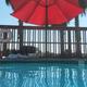 Pool-level view showing the swimming pool, umbrella and decking — illustrates onsite leisure amenity guests can use.