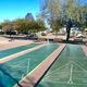 Photo of shuffleboard courts and open recreational area with RVs/trees in background — documents on-site recreation facilities referenced on the property page.