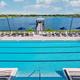 Pool-and-lake view from an elevated angle showing the swimming pool, pier and lakeside setting — highlights waterside amenities and vistas (gallery page).