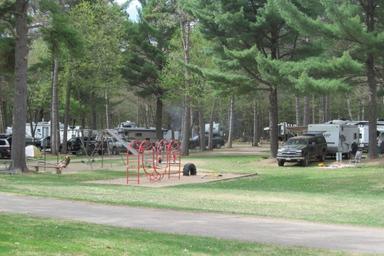 Open campsite area with playground and multiple RVs visible — shows family/RV section and on-site amenities (from photo gallery).