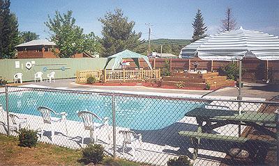 On‑property swimming pool area with fencing, lounge seating and deck features—illustrates recreational facilities available at the campground (from the site gallery).