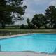 Outdoor swimming pool with fencing, chairs and open field beyond — depicts on-site recreation amenity listed on the campground’s activities/recreation section.