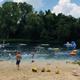 Beach/lake swim area showing shoreline, swimmers and floats — illustrates the campground's waterfront recreation (source: homepage beach image).