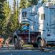 Close view of an RV parked at a gravel site with picnic table and hookups visible — good depiction of the RV pitches and campsite setup; originates from the site gallery.