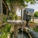 Foreground garden fountain with RVs and parking visible in background — shows landscaping/detail plus nearby RV spaces on the property (gallery page).