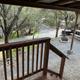 View from a cabin porch looking onto the campsite area with picnic table, fire ring and surrounding trees — provides context for site surroundings and outdoor space (Cabins page).