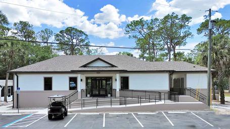Exterior view of the clubhouse building (main amenity building) and parking — useful to show facilities available to guests.