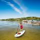 Waterfront scene with paddleboarder and nearby boat docks; illustrates beach/lake access and on-site docks seen in site images.