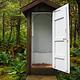 Outhouse door open showing inside toilet with two steps outhouse is surrounded by green trees