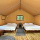 Interior of a glamping cabin/tent with beds and wood floor — useful to show on-site cabin accommodation (from resort accommodation/gallery pages).