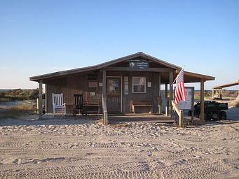 The sandy entrance to the Long Point Cabin Camp Office with beach dune in the background