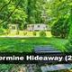 Shows a grassy clearing with two trailers and a walking plank — depicts a campsite/grounds area (Silvermine Hideaway). From the site home page listing this unit, confirms on-property scene.