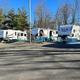 Wide view showing multiple RVs on paved sites and utility hookups — useful overview of RV pitches and site layout; appears on the park homepage.