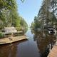 Wide waterfront/boat-dock panorama showing multiple docks and boats along a wooded channel — good aerial-style/overview of the property’s lake access and docks (background/hero image on site).