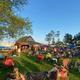 Wide scene of campground grounds with people, tents and pavilion area (social image on homepage). Shows activity and how the grounds are used during events.