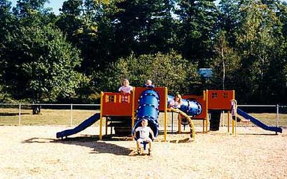 Playground structure with kids — useful for showing on-site recreational amenities; sourced from the campground gallery.
