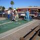 Shuffleboard courts with players, RVs and park buildings visible in background — depicts on-site activities and layout (source page: Rates).