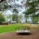 Open grassy campground area with playground equipment and multiple RV sites visible — useful for showing the campground layout and family amenities (from the amenities/images on the site).