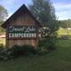 Entrance sign for 'Forest Lake Campground' with surrounding grounds visible — helps identify property and arrival area (homepage image).