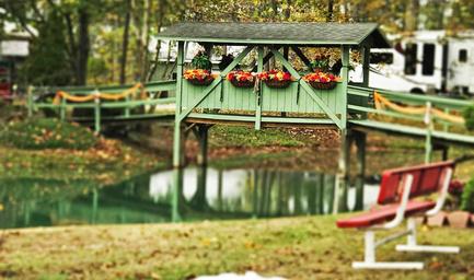 Covered decorative bridge over water with surrounding landscaping and benches — highlights a recognizable on-site feature and scenic walking areas (used as background on the site).