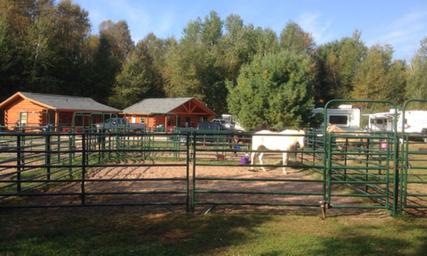 Wide view of fenced horse-pens with cabins and RVs in background — useful overall view of the ranch layout and mixed-use guest areas (from Horse Accommodations gallery).