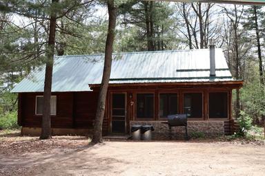 Front view of a numbered cabin with picnic table and grill — clear cabin exterior representative of the resort's lodging (appears on property pages).