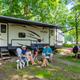 Clear photo of an RV site with picnic table, fire ring and shaded trees — depicts typical RV camping spaces (from RV Sites page/primary RV image).