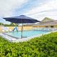 Clear photo of the resort swimming pool and clubhouse area with umbrellas and fencing — matches pool shown on the property page and banner images on the site (resort amenities).