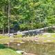 Panoramic view of a pond/grounds with picnic table and surrounding trees — useful scenic overview of the campground property. Source: background/hero image on the homepage.