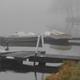 Moored boats and small docks in a misty morning scene on the lake — atmospheric view of the property’s waterfront and docks (homepage slider).