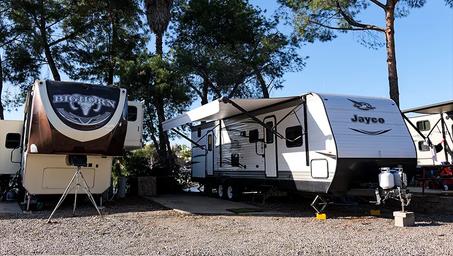 Clear photo of RV spaces with multiple rigs parked, showing typical paved/gravel pads and site setup — useful for prospective RV guests.