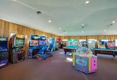 Indoor arcade/game room with multiple machines and pool table — documents additional on-site amenities available to guests (part of the property’s facilities images).