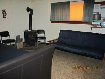 A wood stove with two futons couch-beds in a living room.