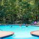 Wide pool view showing the on-site swimming facility and surrounding wooded setting — good facility shot. Source: 'Our Campground' page header image.