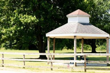 Gazebo/pavilion and fenced picnic area on grassy grounds — highlights on-site recreational/amenity space (from features/facilities images).