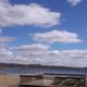 Sandy beach and lakeside deck with picnic tables looking across the lake — shows on-site waterfront recreation area referenced on the property page.