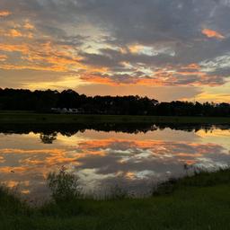 Scenic lakeside sunset reflection across the water — highlights the property's lake scenery and ambiance; from the 'Our Community' gallery on the site.