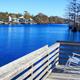 Wooden dock with rocking chair overlooking the waterway — strong scenic shot of the campground pond/Intracoastal frontage featured on the site.